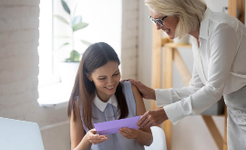 אישה צעירה מקבלת מתנה במעטפה. תמונה מ- Shutterstock